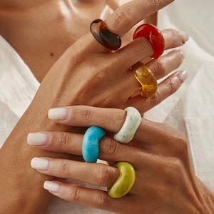 Minimalist acrylic resin rings in various colors worn by model for fashion styling