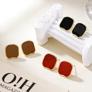 Close-up of retro enamel rectangular stud earrings in black red and brown finish