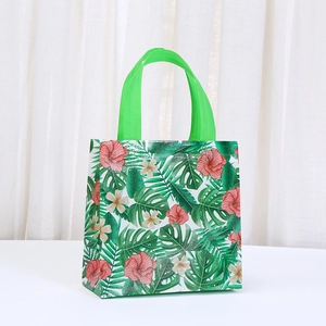 Detail of tropical Hawaiian print non-woven gift bag with hibiscus flowers and green handles