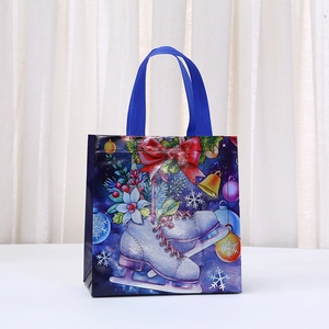 Detailed view of Christmas non-woven gift bag with ice skate prints and sturdy blue handles