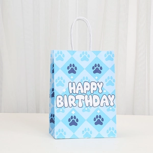 Blue dog paw print paper gift bag with Happy Birthday text and white woven handle