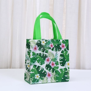Hawaiian non-woven gift bag with tropical monstera leaves and hibiscus floral print