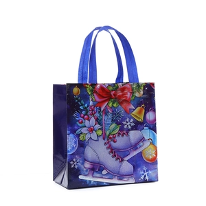 Blue non-woven Christmas gift bag featuring ice skates, bells, and red bow illustration