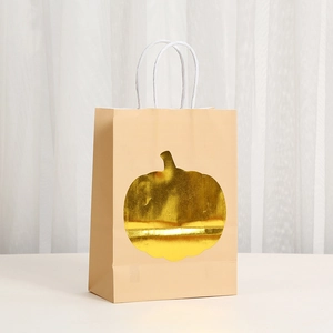 Close-up of brown Kraft paper gift bag with golden foil pumpkin and white twisted handles
