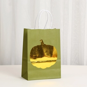 Detail of green Thanksgiving gift bag with gold foil pumpkin and white woven handles