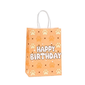 Orange kraft paper gift bag with happy birthday text and dog paw prints on white background