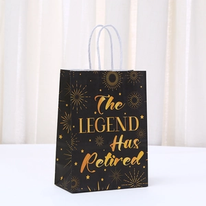 Detail of black paper gift bag with gold foil The Legend Has Retired print and white handles