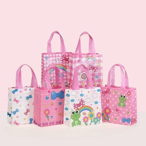 Close-up of pink non-woven gift bags featuring cartoon frogs and rainbow prints