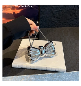 Close-up of a silver bow-shaped metallic evening bag with a sleek chain strap