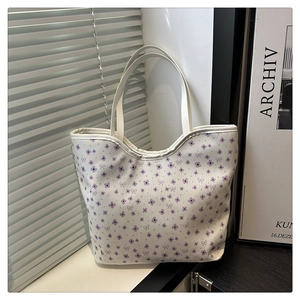 Detail of floral canvas tote bag with purple flower patterns near white shutters