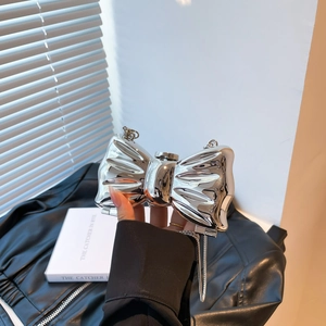 Mini silver metallic bow crossbody bag with a shiny mirror finish and chain strap