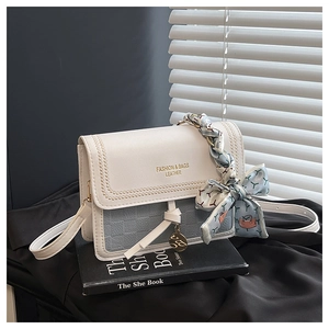 Detail of color-block square bag with silk scarf handle and golden fashion lettering