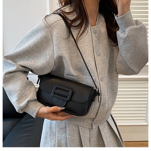 Chic black rectangular leather handbag featuring a large square buckle and slim shoulder strap