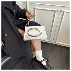 Minimalist white leather handbag featuring a bold horseshoe-shaped gold metal clasp detail