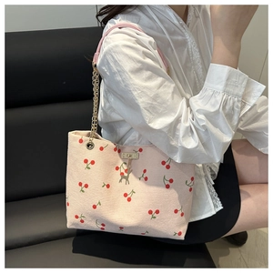 Détails du sac cabas en velours côtelé rose avec motifs cerises et pendentif cerf