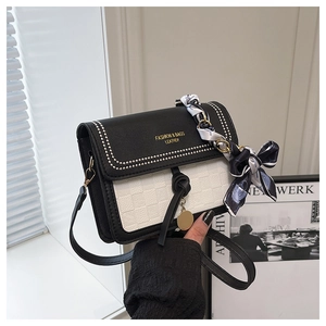 Detail of black and white checkered crossbody bag with gold chain and floral scarf