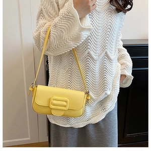 Detail of yellow minimalist satchel with square buckle and matte leather texture