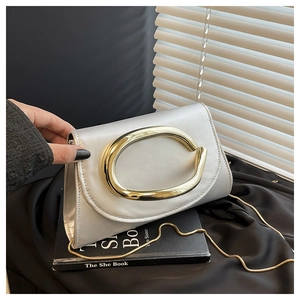 Detail of silver satin clutch with gold oval handle and delicate gold chain strap