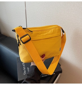 Detalle del bolso bandolera amarillo impermeable con múltiples capas y correa ancha