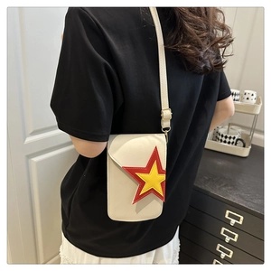 Détail du sac à bandoulière blanc cassé avec patch étoile bicolore et boucles dorées