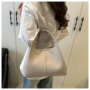 Beige Beuteltasche aus Leder mit Litschimuster in Seitenansicht am weiblichen Model