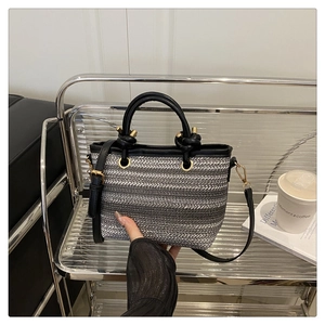 Detail of silver woven texture on a bucket bag with premium black leather strap