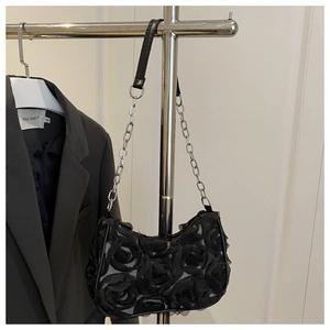 Detail of black lace shoulder bag featuring 3D rose textures and silver chain strap
