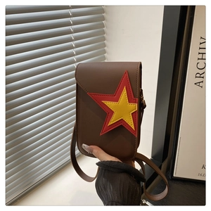 Gros plan sur le sac de téléphone marron avec décoration étoilée rouge et jaune