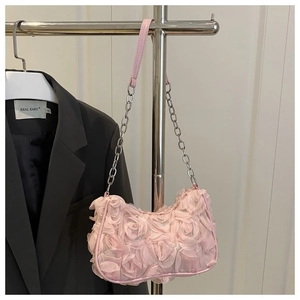 Detailed view of pink floral shoulder bag with 3D petals and silver chain strap decoration