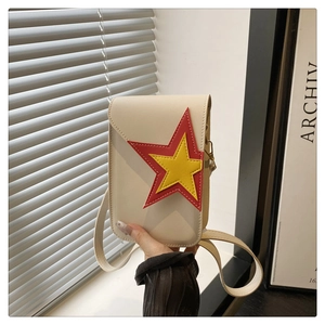 Détail d'un sac carré vertical beige avec broderie en forme d'étoile rouge et jaune