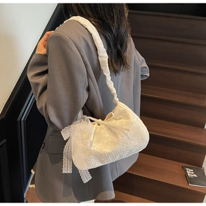 Detail of white floral lace tote bag with oversized side bow and ruched shoulder strap