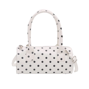 White cylindrical polka dot handbag with glossy finish and detachable crossbody strap
