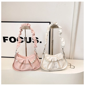 Détail du sac demi-lune plissé avec une chaîne argentée et trois perles élégantes