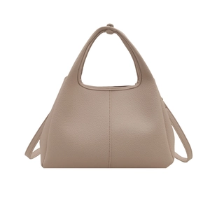 Minimalistische beige Bucket Bag aus Leder mit Griff und Schultergurt auf weißem Grund