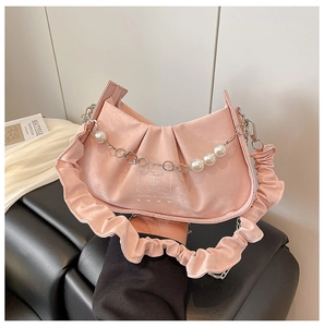 Détail du sac froncé en satin rose avec chaîne en perles et poignée à volants chic