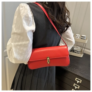 Rear view of a model wearing a red leather underarm bag with a gold oval metal clasp