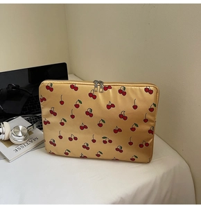 Detail of cherry pattern laptop sleeve with durable double metal zippers in mustard yellow