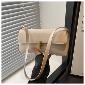 Detail of minimalist beige underarm bag with elegant gold twist lock and smooth leather texture