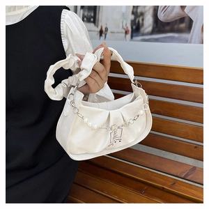 Detail of cream pleated shoulder bag with pearl floral chain and stamp label