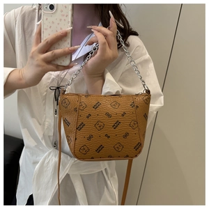Detail showing brown textured leather texture and teddy bear print on bucket bag