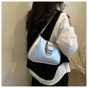 Borsa a spalla argento con maxi fibbia dorata e texture in pelle indossata da modella