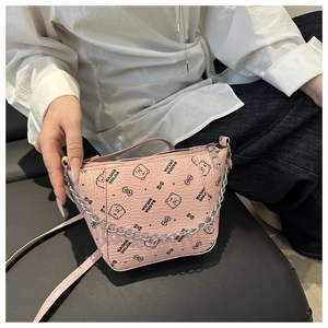 Pink bucket bag with bear print and chain strap shown on a white shirt background