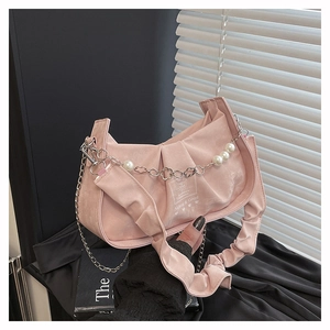 Detail of pink pleated handbag with suede texture and pearl-decorated silver chain strap