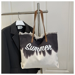 Detail of frayed edge canvas tote with Summer print and brown leather handles