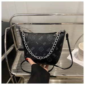 Detail of black leather bucket bag with silver metal chain and bear print pattern