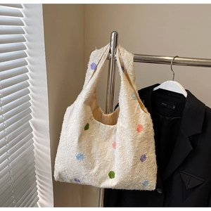 Detail of white textured hobo bag with colorful embroidered polka dots and soft lining