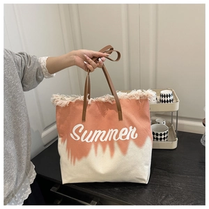 Détail des franges et imprimé Summer sur le sac de plage en toile dégradé orange