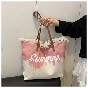 Gros plan du sac cabas en toile rose avec imprimé Summer et détails à franges