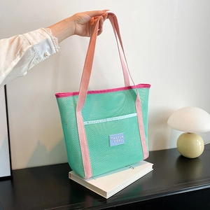 Green mesh tote bag with pink handles for kids pool or outdoor storage usage