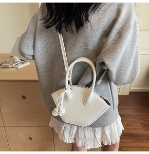 Vue détaillée du sac à main blanc asymétrique avec nœud décoratif sur un mannequin